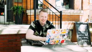 Front-end developer Wes Bos sits at a laptop at a garden table