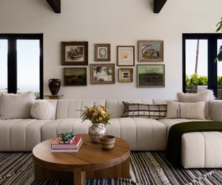 A California modern living room with a white sofa, warm neutral walls and vintage art displayed on the wall