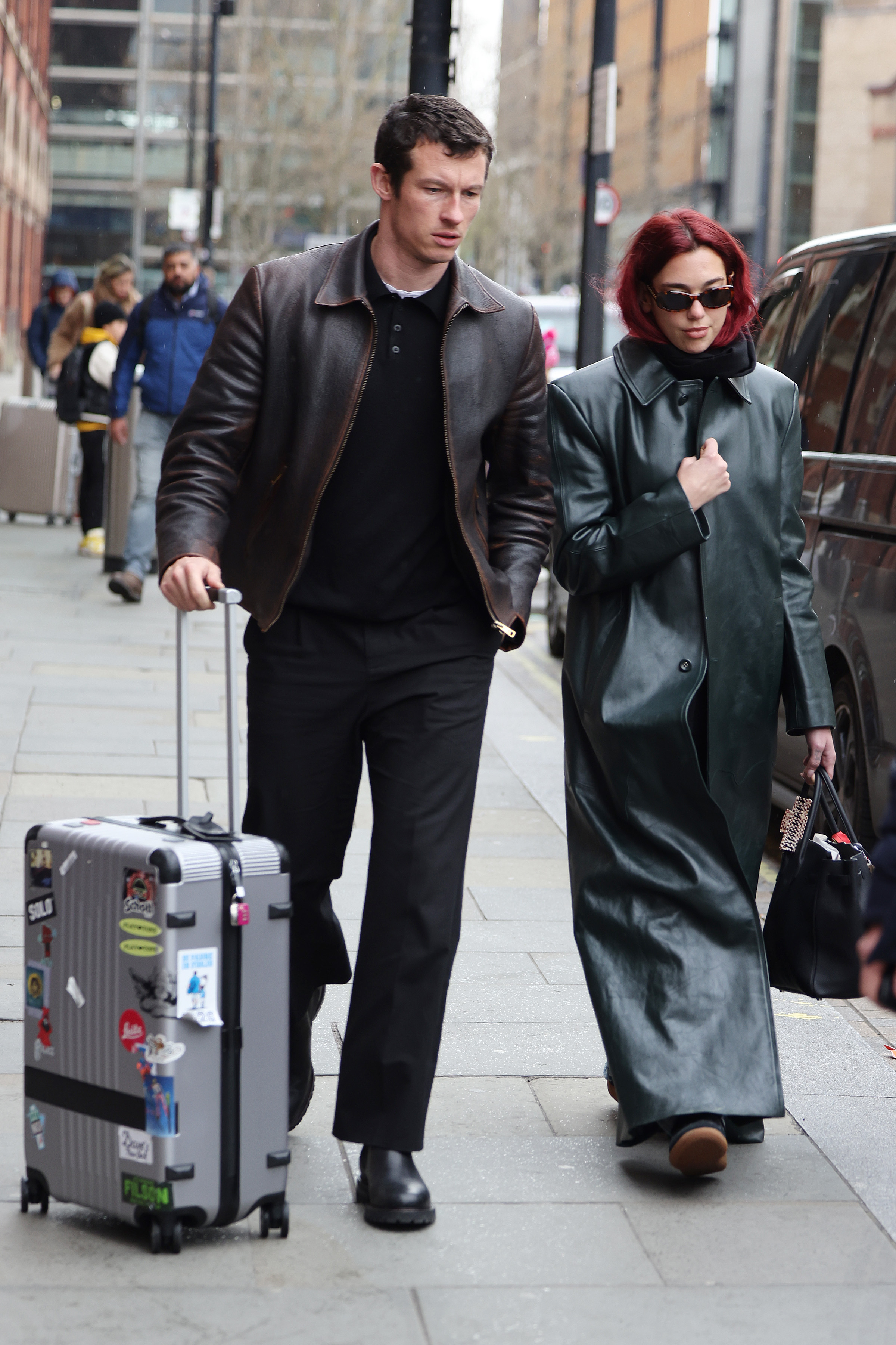 Dua Lipa and CallumTurner walking outside Kings Cross station