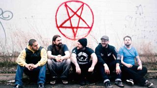 The Black Dahlia Murder sitting under a grafitti’d pentagram