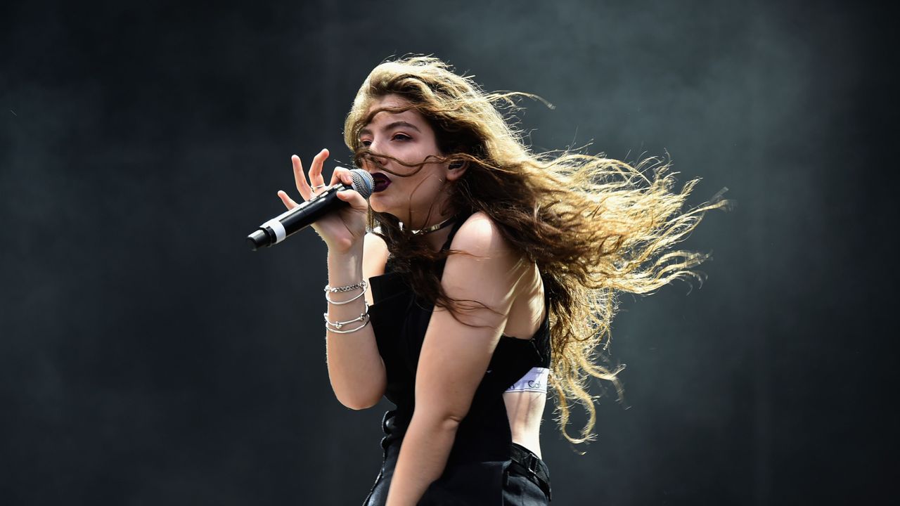 Lorde singing into a microphone on stage