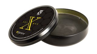 A pot of black wax in a black tin