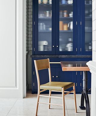 Kitchen with a dark blue dresser, a ceramic tiled floor and a kitchen table and chairs.