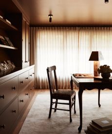 home office with brown walls and millwork