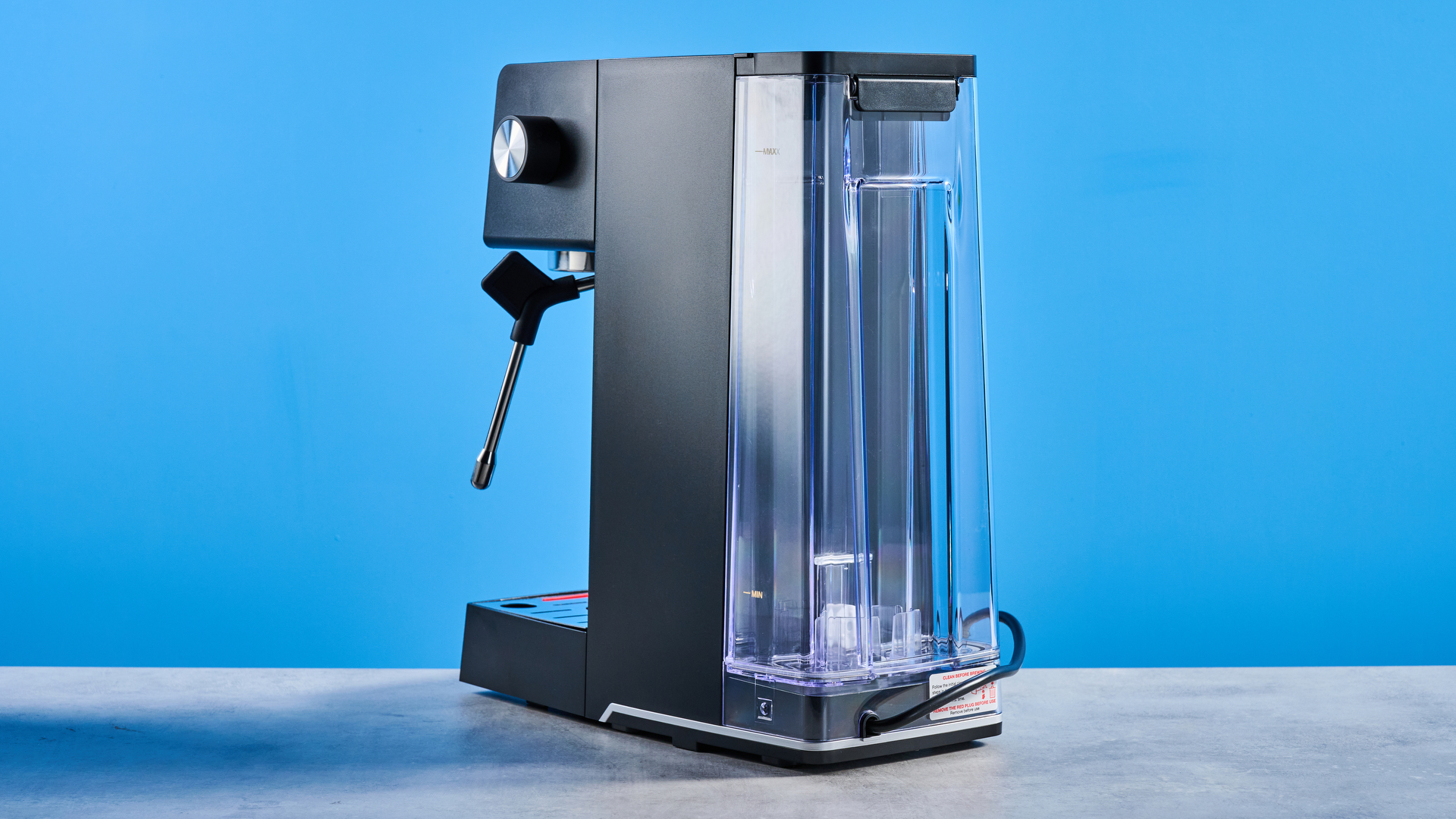 The Cuisinart Espresso Bar Slim espresso machine on a stone surface with a blue background