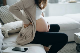 Signs of labor: A pregnant woman holds her belly during a contraction