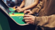 Teenagers playing retro arcade machines