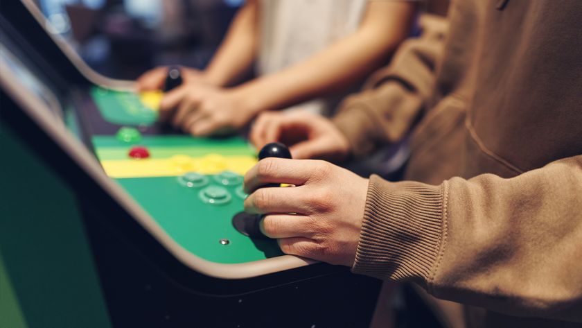 Teenagers playing retro arcade machines