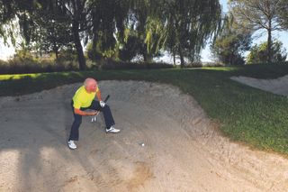 Keith Williams in the sand assessing his options prior to playing a long bunker shot