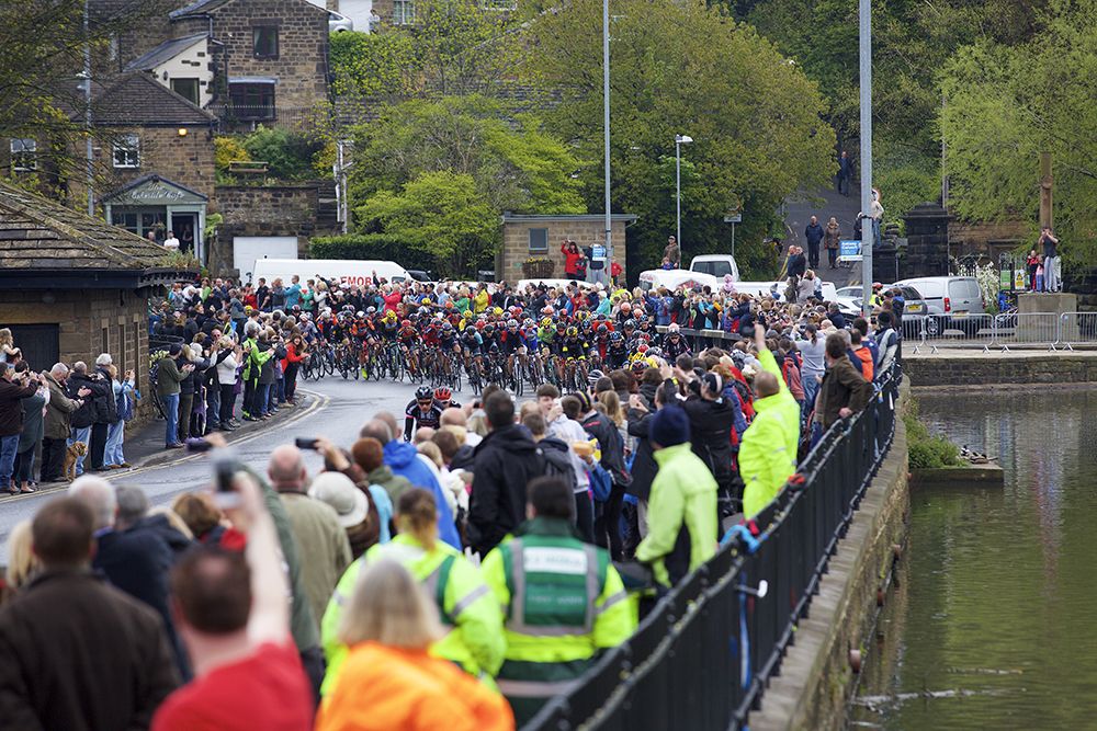 Fans watch the peloton pass by on stage three