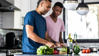 Two guys cooking with healthy ingredients in a kitchen
