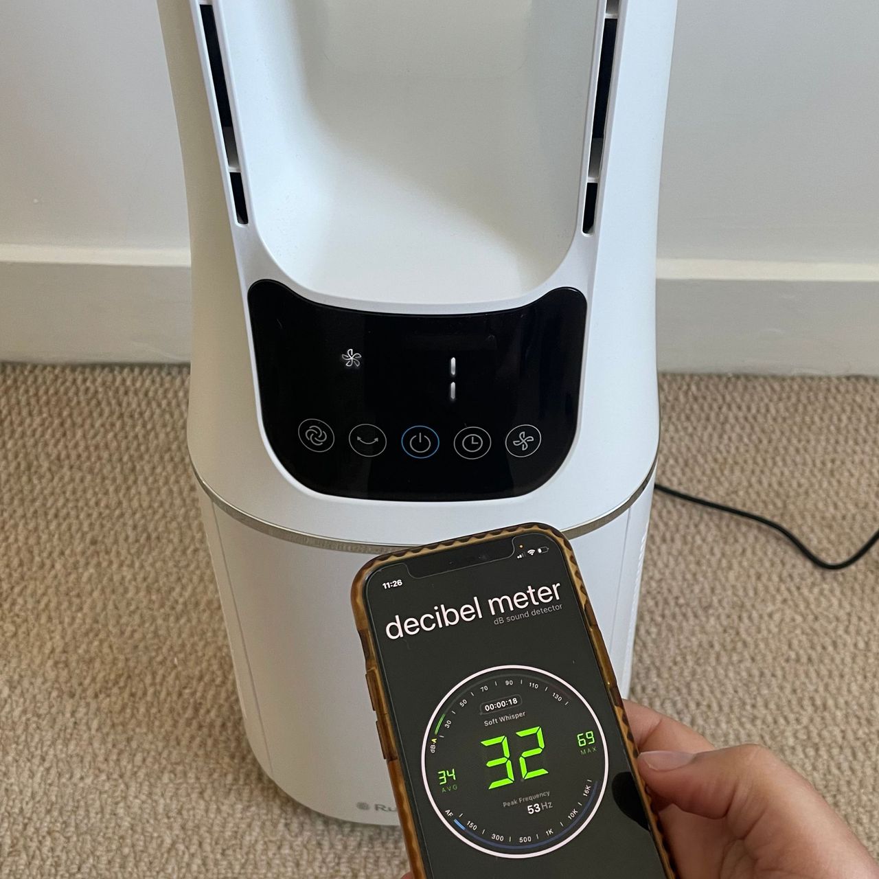 Russell Hobbs RHBLDL12 Bladeless Tower Fan with a hand holding a phone with a decibel meter app on it, which reads 32dB