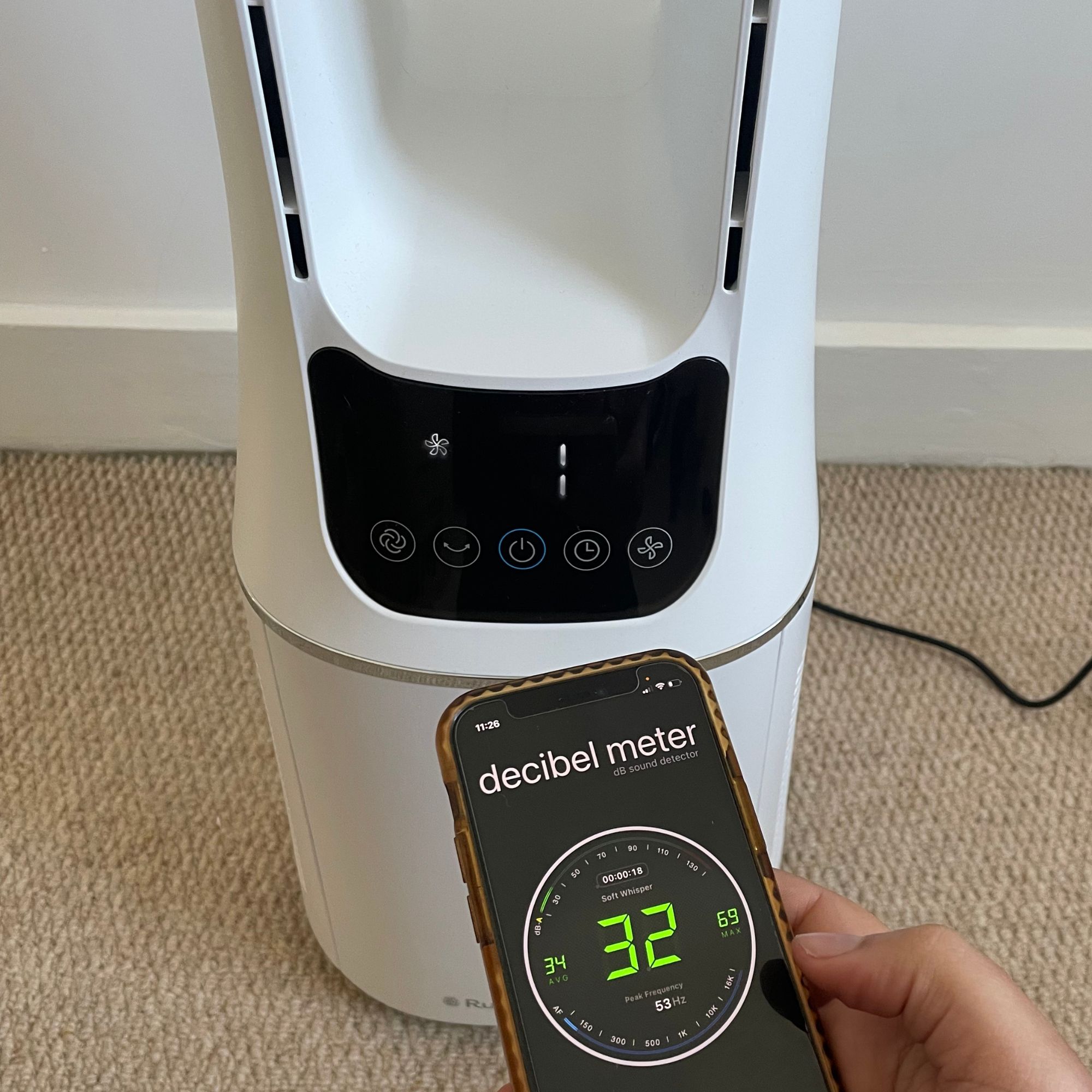 Russell Hobbs RHBLDL12 Bladeless Tower Fan with a hand holding a phone with a decibel meter app on it, which reads 32dB