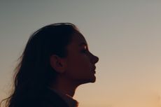 Portrait Of Young Woman Looking Away Against Sky During Sunset