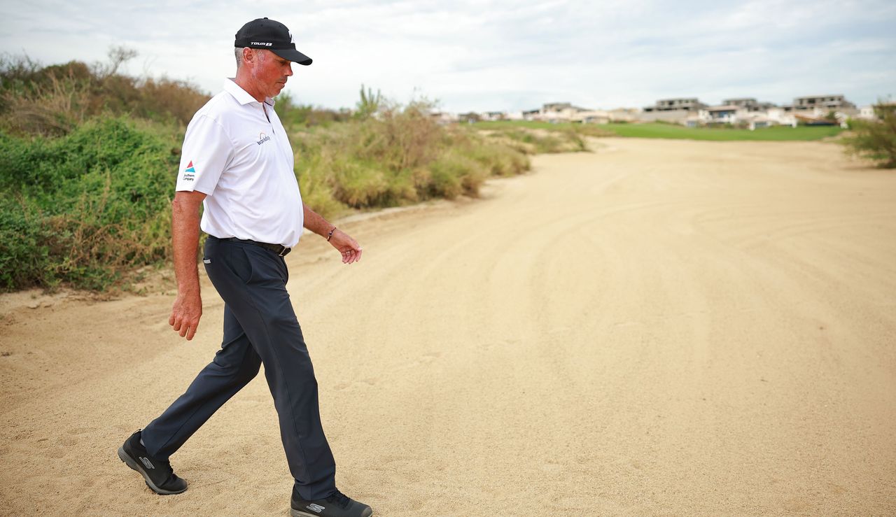 Matt Kuchar walks across the sand