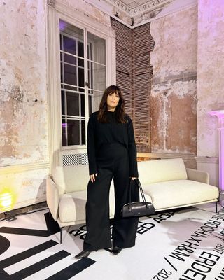 @annacascarina wearing black wide-leg trousers and top