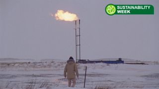A person walks towards a gas station while in the snow