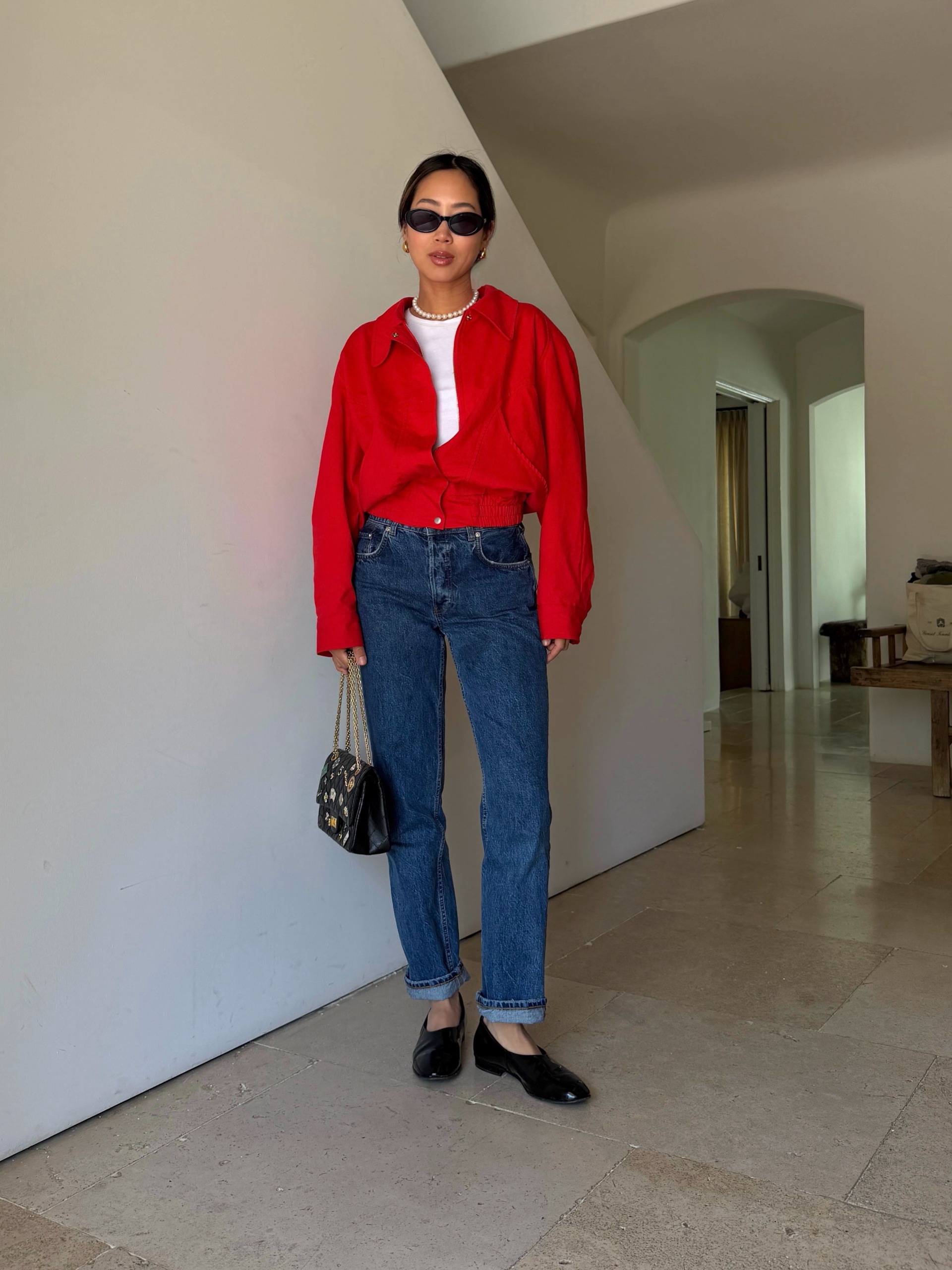 Influencer wearing a red button-down over a white tee with jeans and high-vamp black flats
