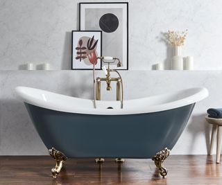 blue roll top bath on dark wooden floor in bathroom