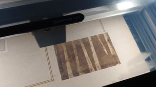 The Glowforge Pro review shows a tree engraving being created