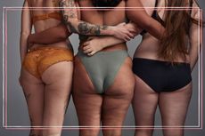 Three women in their underwear photographed from behind with their eyes around each others' waists