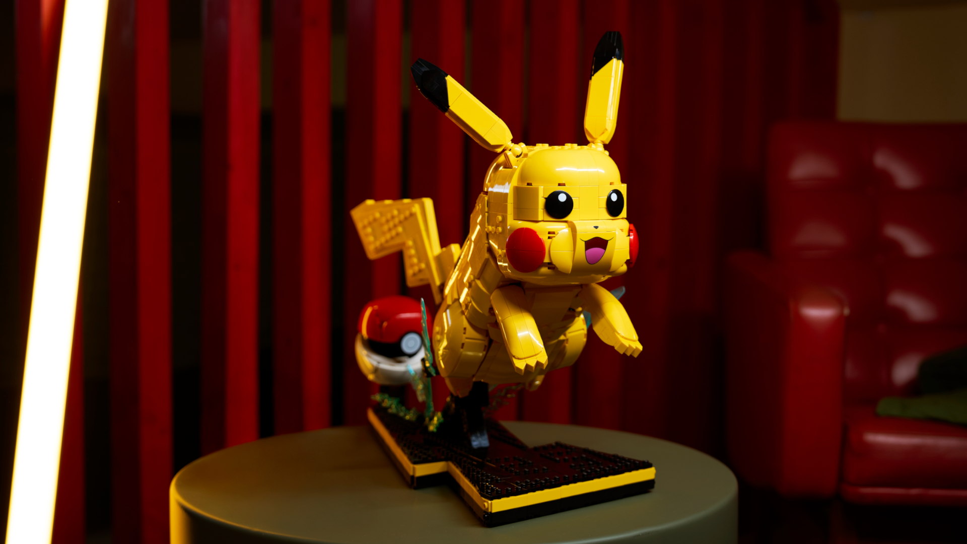 Lego Pikachu and Poke Ball set on a table against a red-curtained backdrop