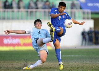 Northern Mariana Islands player Lucas Knecht (left) challenges Nepal's Santosh Shahukhala in a match in March 2013.