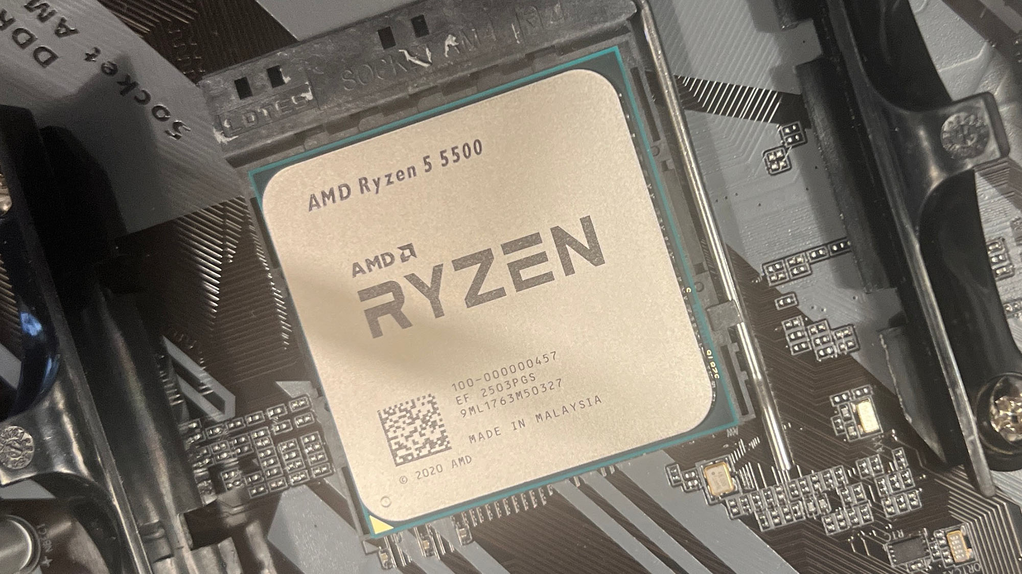 An AMD Ryzen 5 5500 slotted into a motherboard socket.