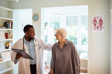 A doctor speaks with a patient who looks happy. 