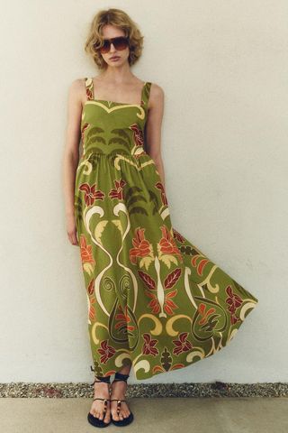 A model wears a long green Zara dress with a botanical print
