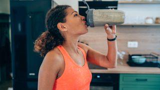 Woman drinking protein shake at home