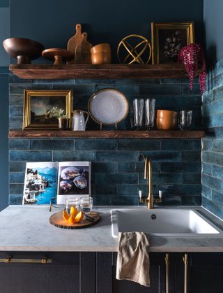 prettily arranged shelves above a sink and blue tile