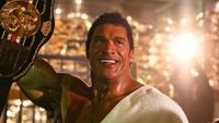 Dwayne Johnson's Mark Kerr holding championship belt and smiling in The Smashing Machine
