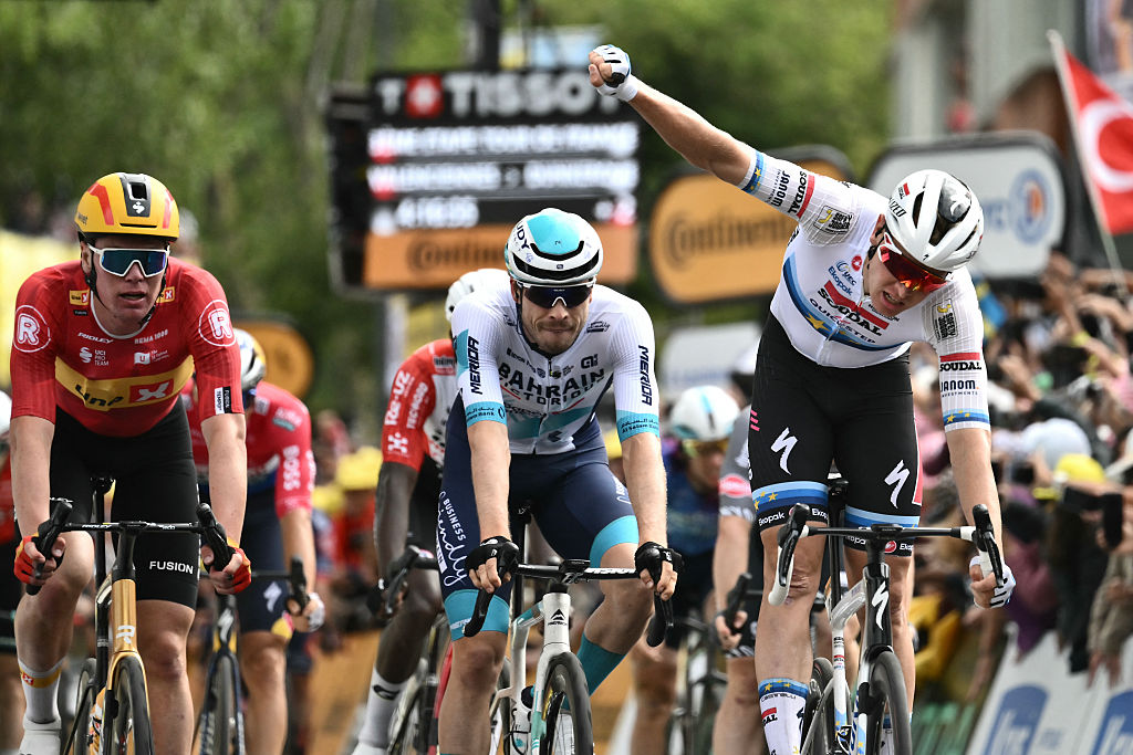 Soudal Quick-Step team's Belgian rider Tim Merlier (L) celebrates winning the 3rd stage of the 112th edition of the Tour de France cycling race, 178.3 km between Valenciennes and Dunkerque (Dunkirk), Northern France, on July 7, 2025. (Photo by Marco BERTORELLO / AFP) (Photo by MARCO BERTORELLO/AFP via Getty Images)