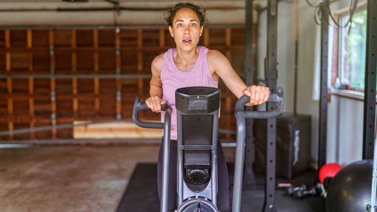 Woman riding air bike in garage