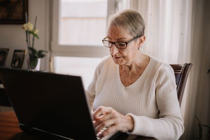 Senior woman using her laptop on the table at home
