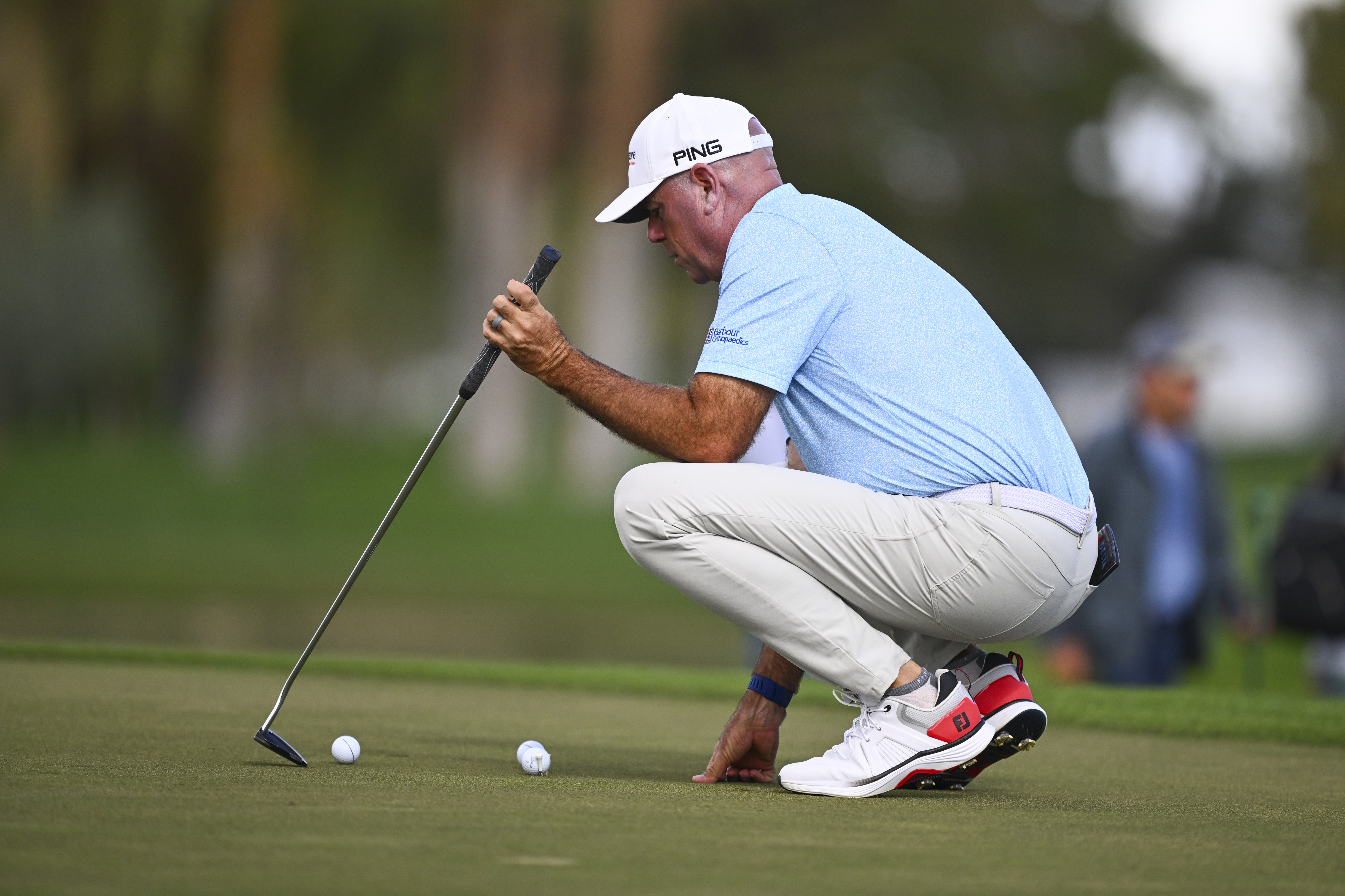 Stewart Cink lines up golf balls on the practice green