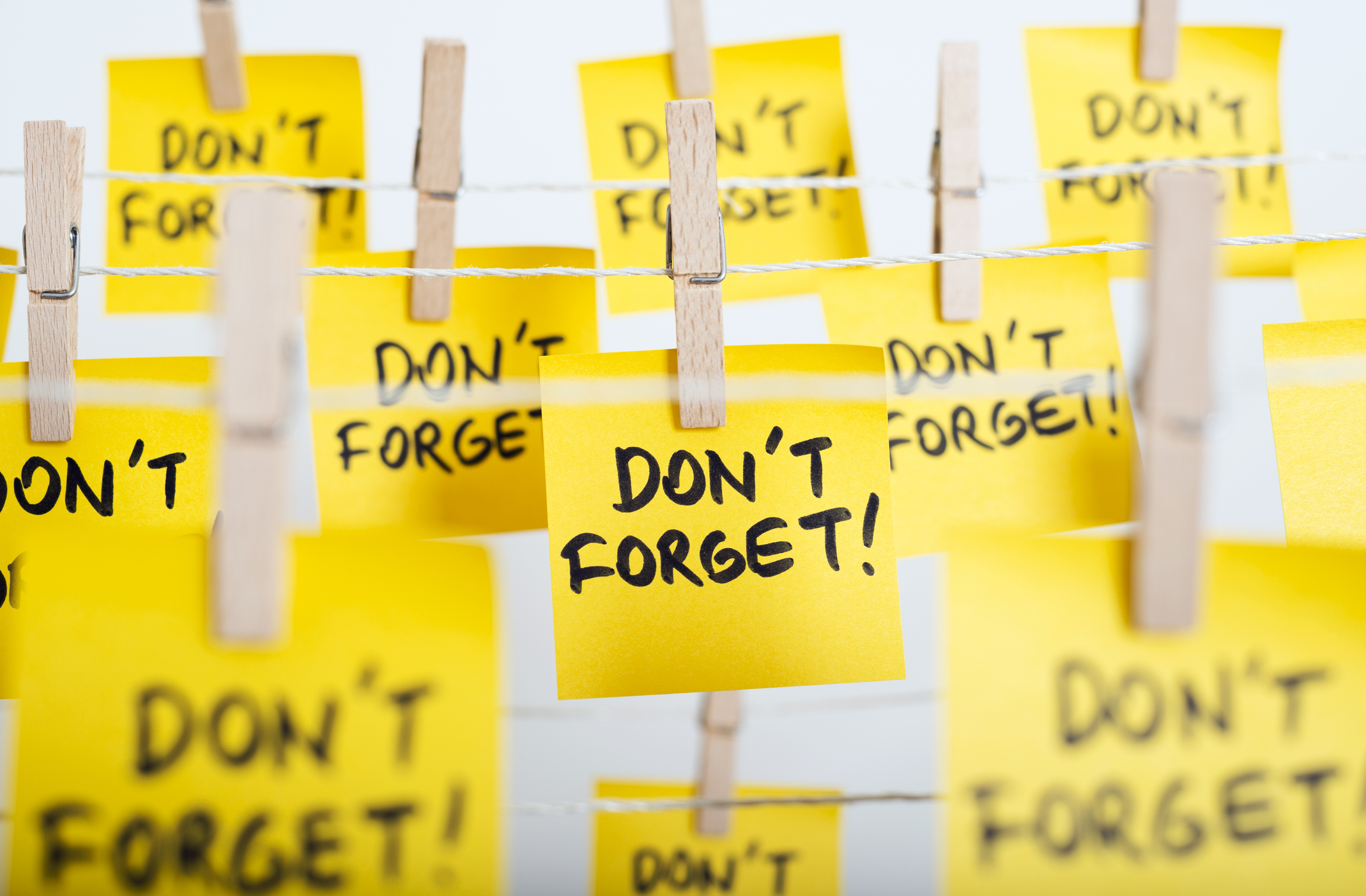adhesive note papers with "don&amp;amp;apos;t forget!" message hanging on the rope