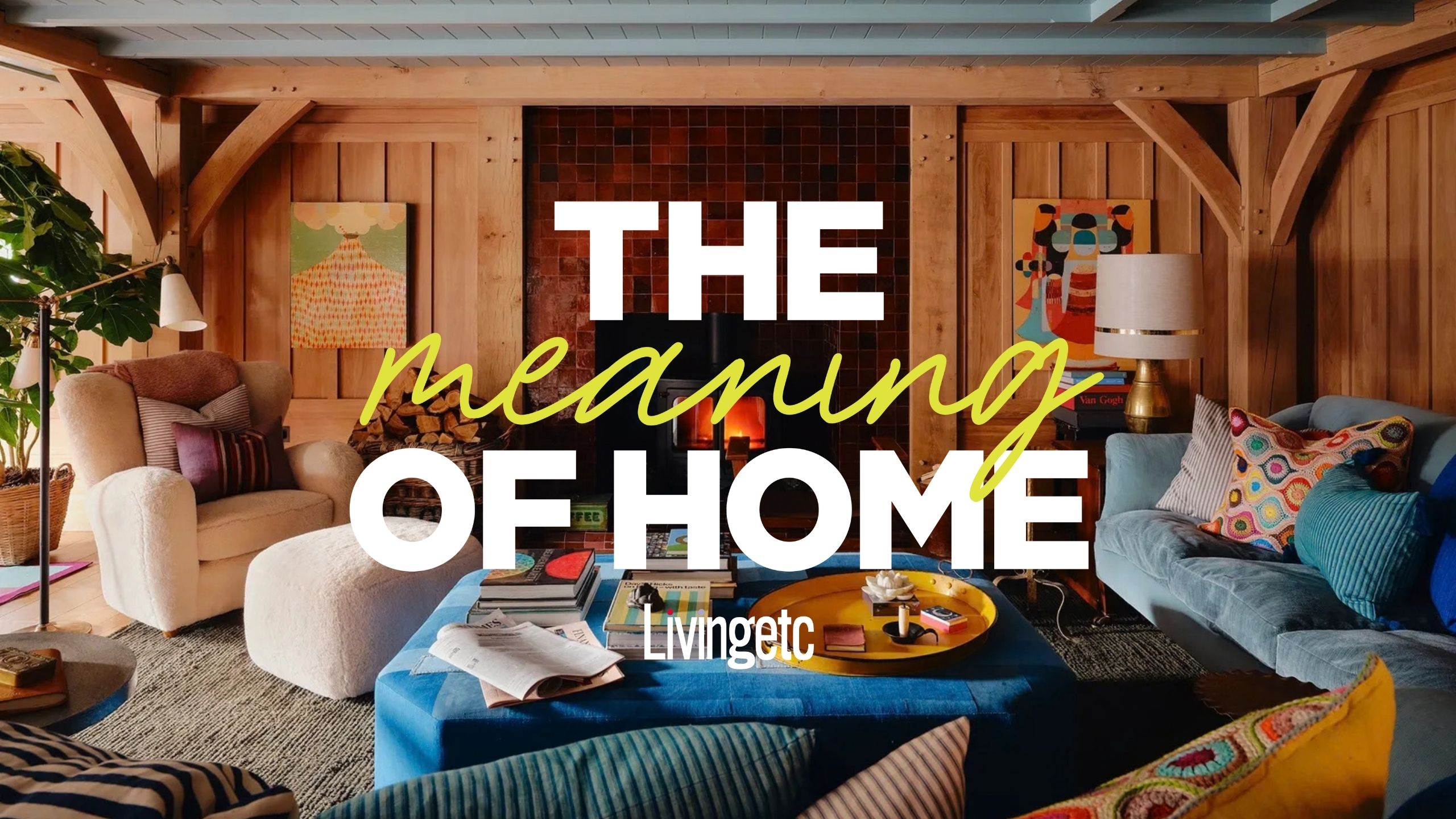 A cozy living room with a lit-up fire, pale wood walls, and eccentrically colored sofas and cushions in multiple shades of blue, ochre, butter, and orange, and shapes, styled with funky artwork.