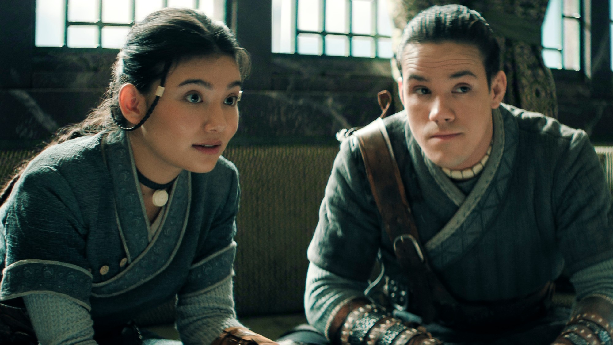 Katara and Sokka sitting next to each other and looking forward. 