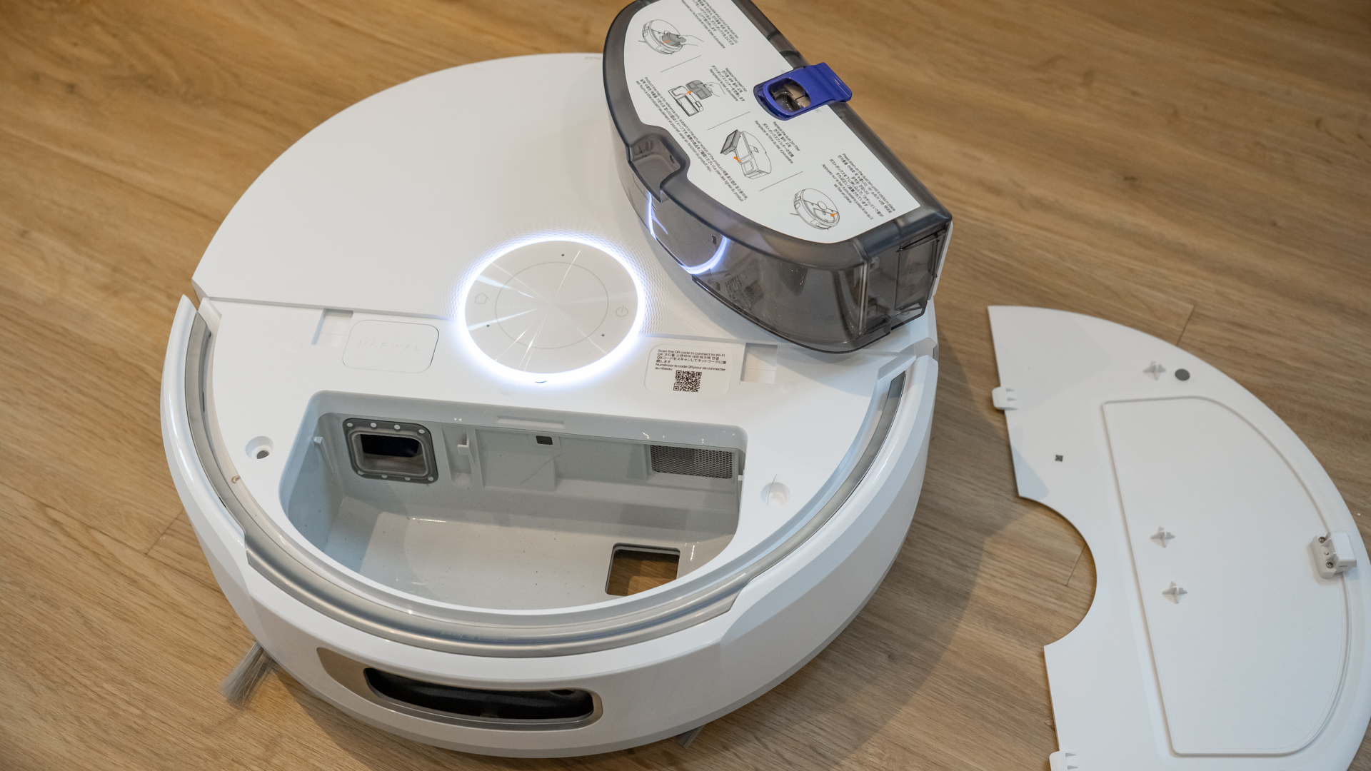 Narwal Flow robot vacuum with internal dust cup removed and placed on top