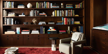 sitting room with red rug and wall of books