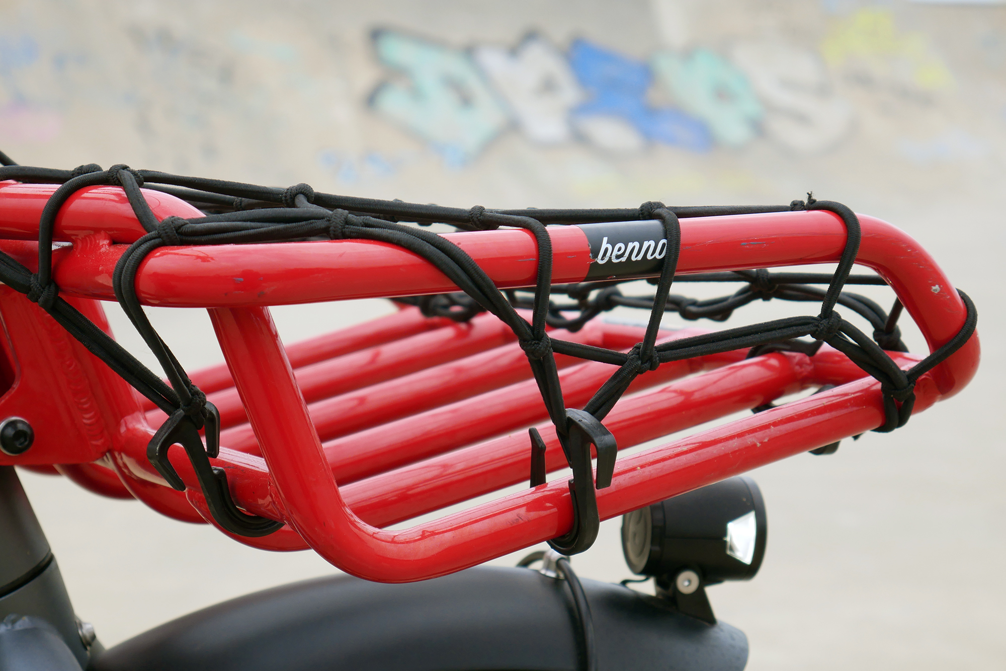 Red Front rack of the Benno RemiDemi XL against the backdrop of a concrete skatepark