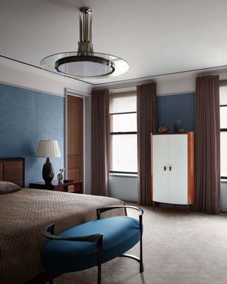 A blue bedroom anchored with darker tones