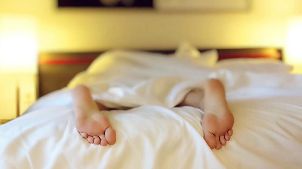 Person Lying on Bed Covering White Blanket