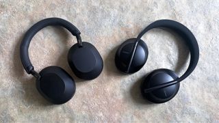 Sony WH-1000XM5 and Bose 700 headphones side-by-side on a stone floor