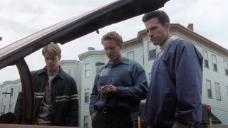 From left to right: Matt Damon, Cole Hauser holding a beer and Ben Affleck all looking down at a car in Good Will Hunting.