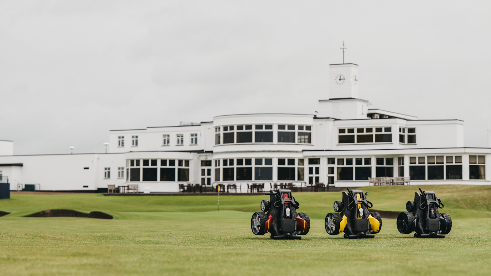 Three Stewart Golf trollies in front of Royal Birkdale's clubhouse