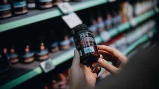 A person inspecting a pill bottle in a pharmacy