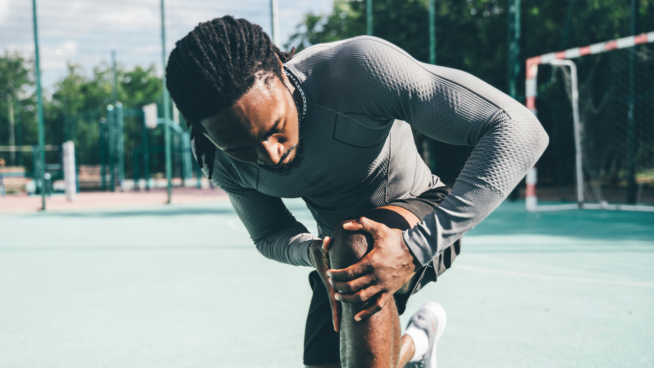 Man grasping knee in pain mid run